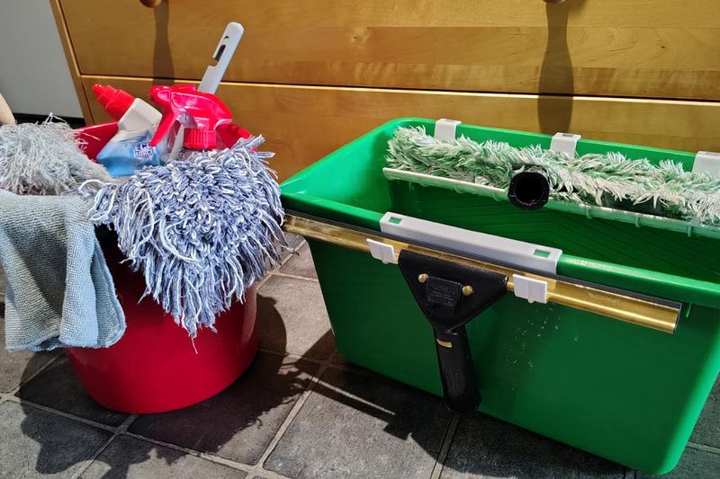 Städutrustning: hinkar, moppar och en fönsterskrapa